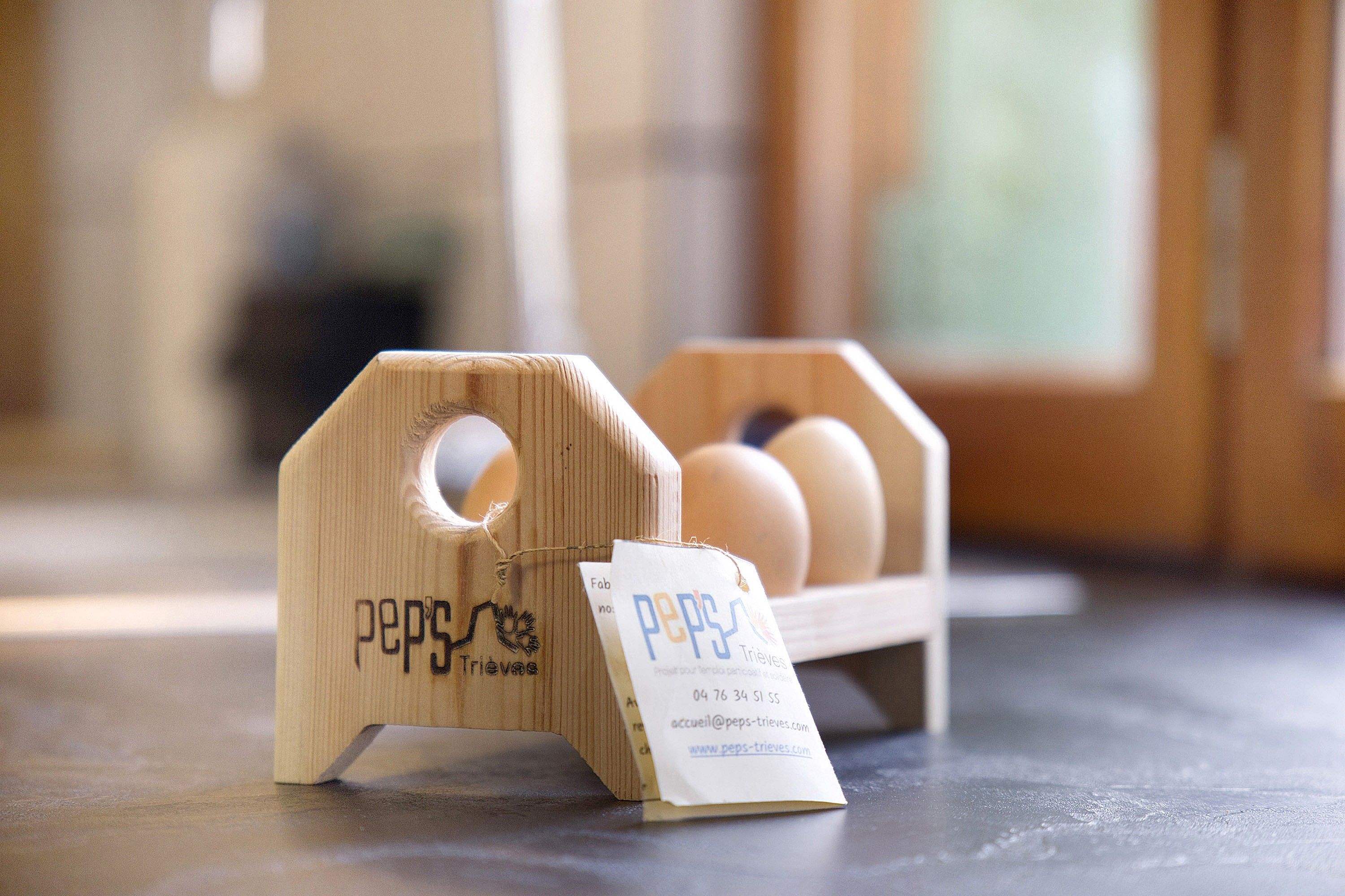 A wooden egg carton with a label, placed on a table.