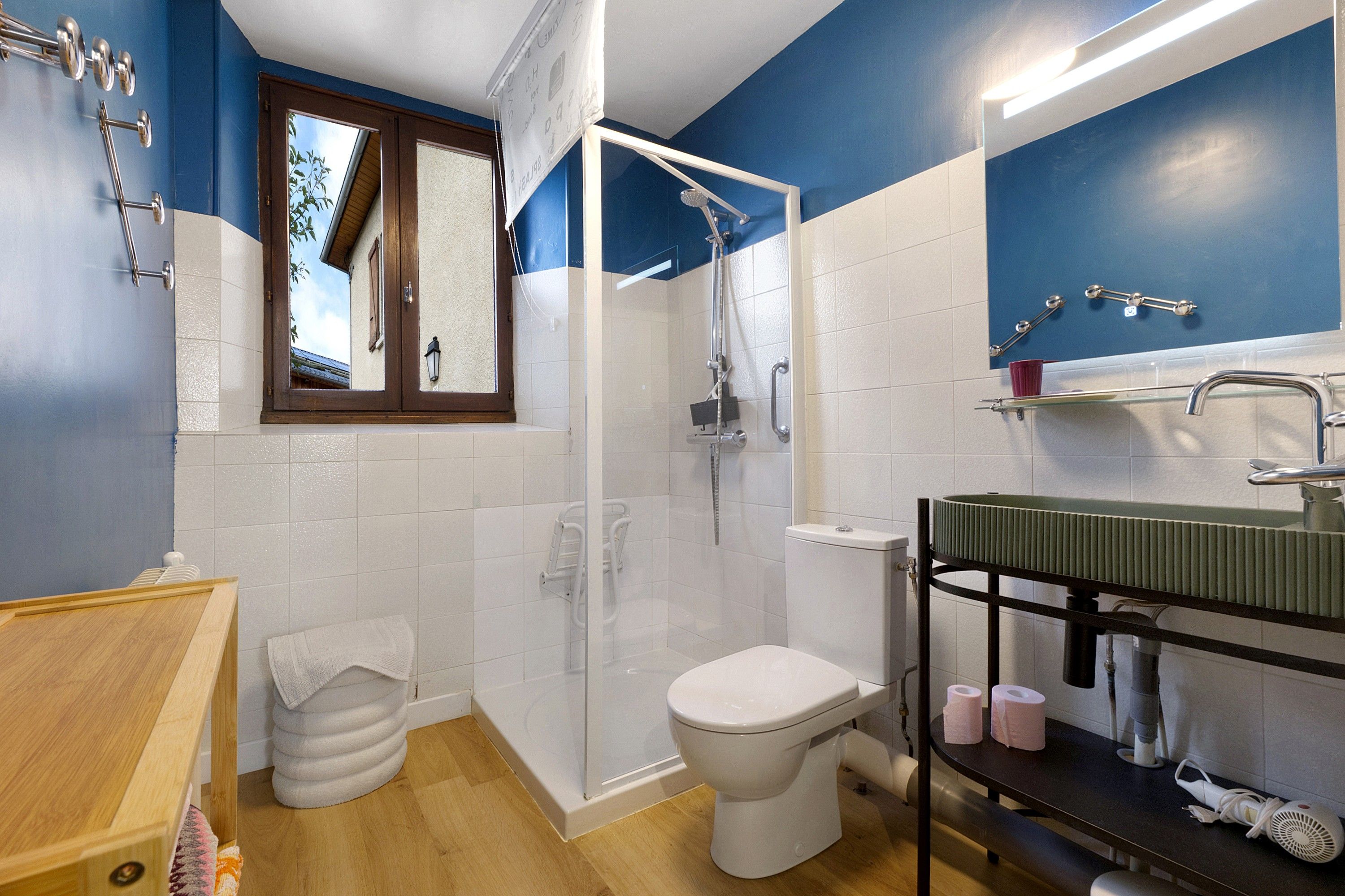 Een badkamer met douche, toilet, wastafel en spiegel.