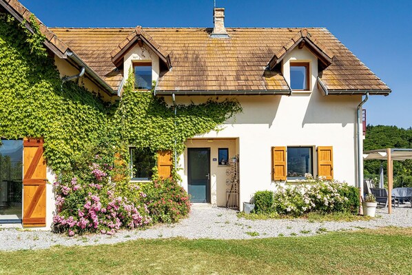 A two-story house with a sloped roof, a front entrance, and a small porch area. - Holiday Home 'La Bayloune' with Mountain View, Private Terrace and Wi-Fi (Lavars)