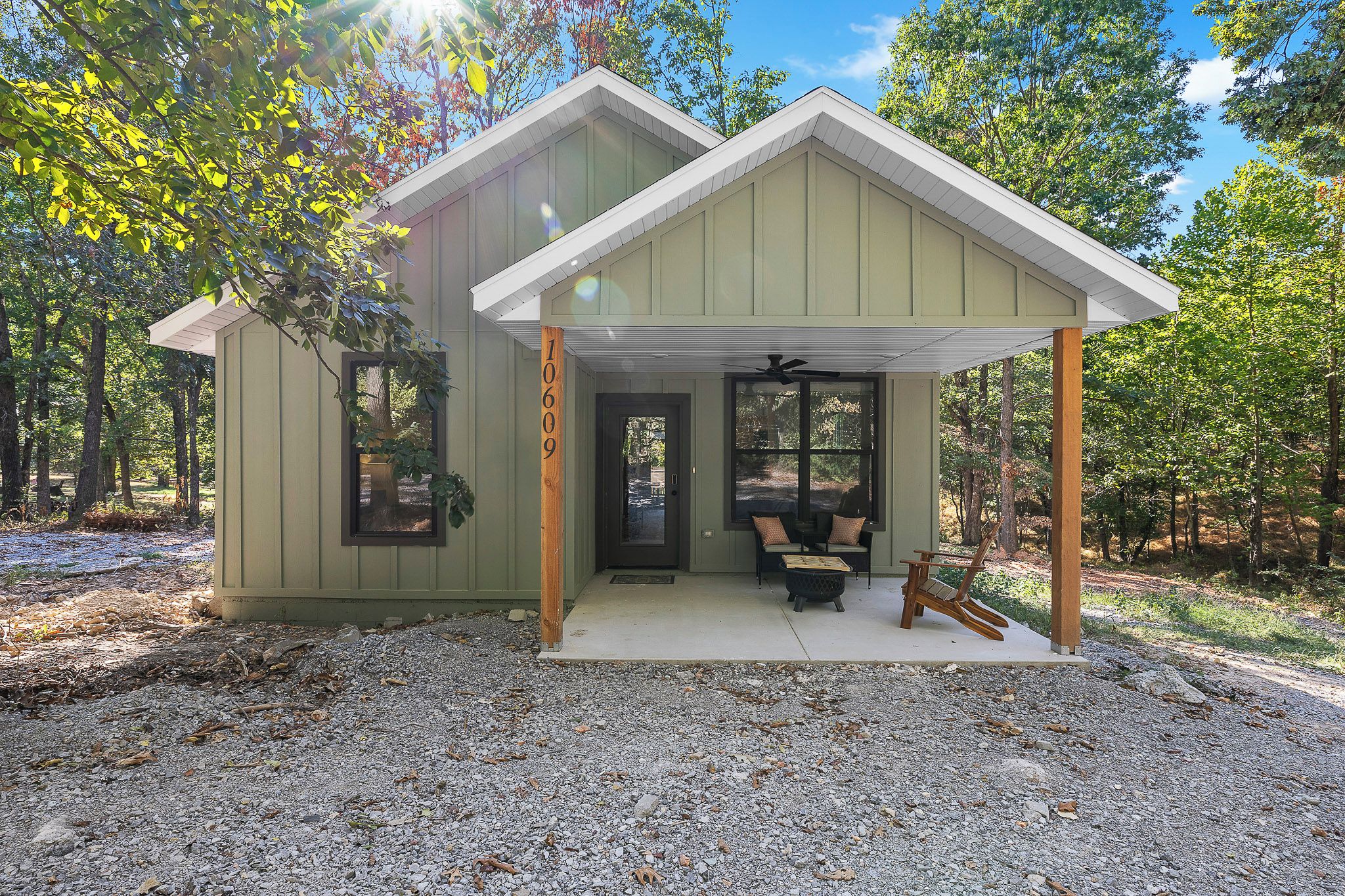 Eine kleine Holzhütte mit Veranda, Tür und Fenster.