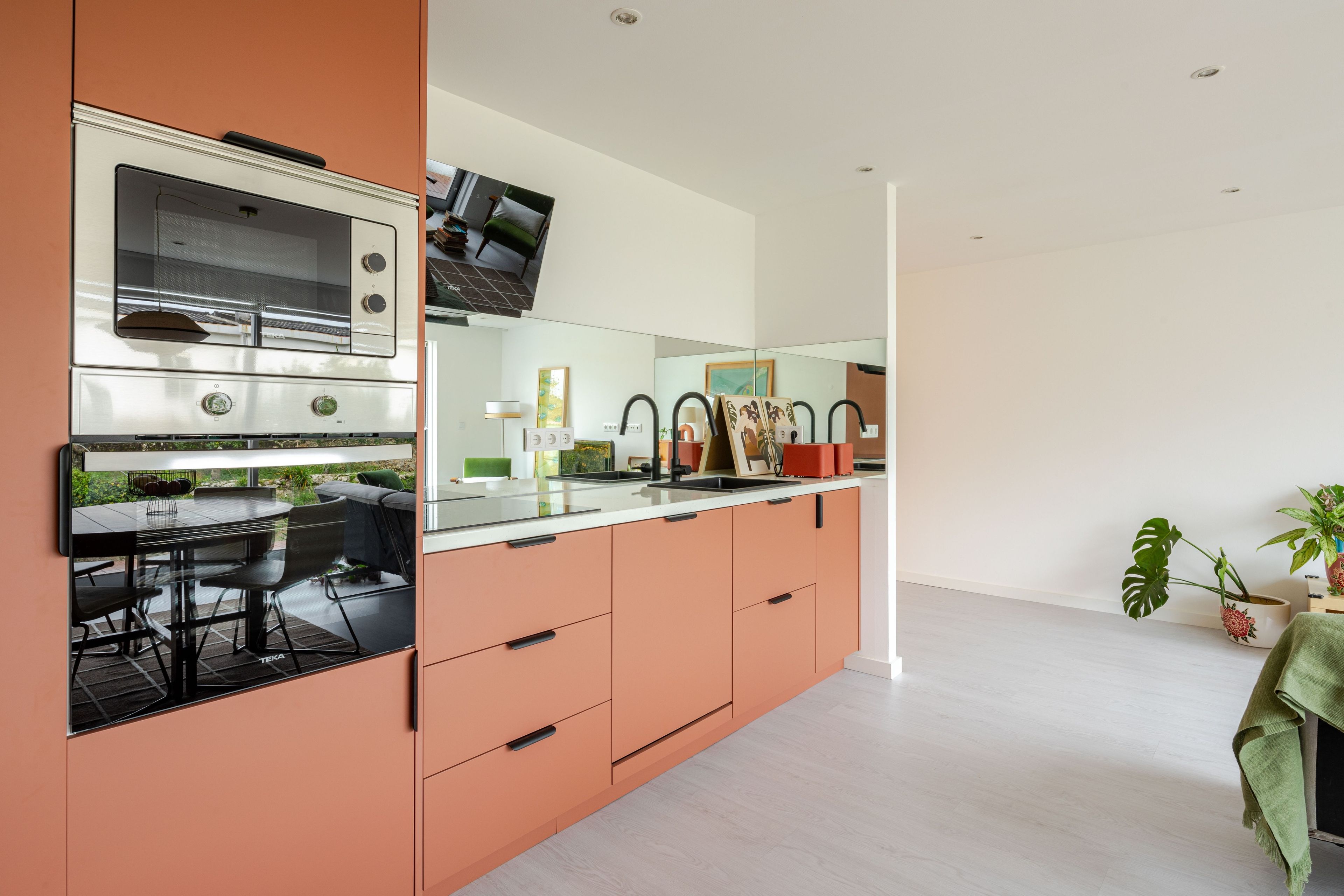 Eine moderne Küche mit Backofen und einem Essbereich, inklusive Tisch und Stühlen.