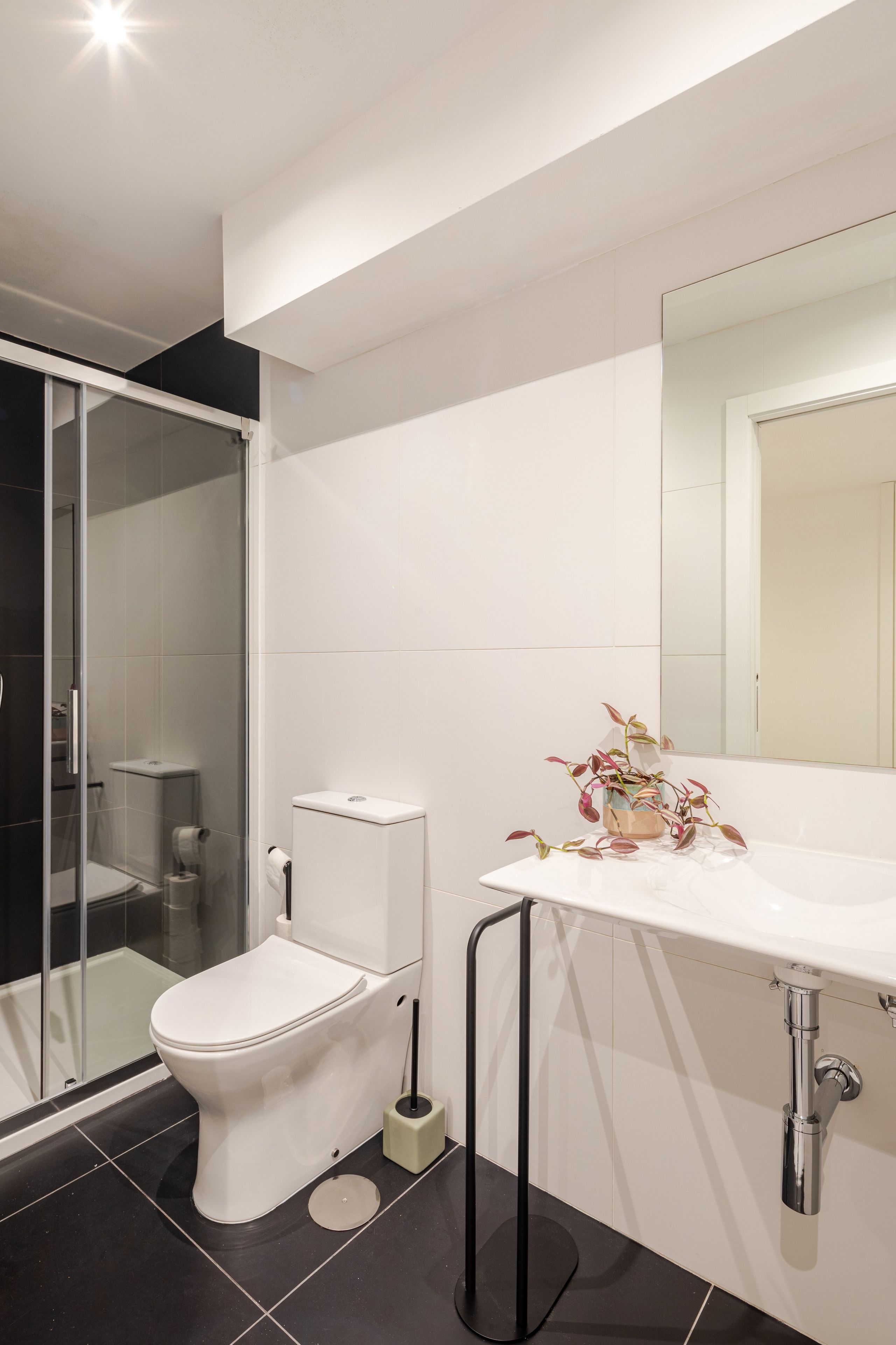 Une salle de bain moderne équipée de toilettes, d’un bidet et d’une douche à parois de verre.