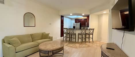 A living room with a sofa, a coffee table, and a TV stand.