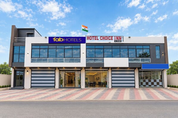 Un moderno edificio de hotel con un cartel que dice 'fabHOTEL' y 'HOTEL CHOICE INN'.