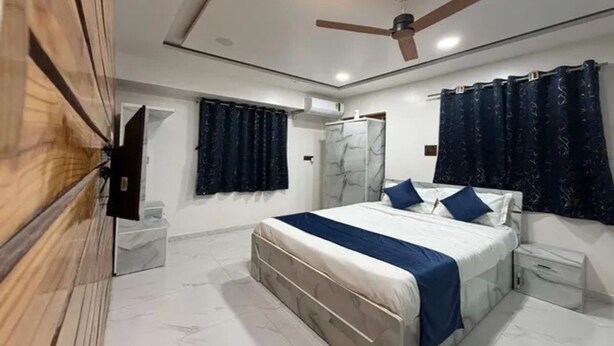 A bedroom with a bed, a ceiling fan, and a wardrobe. - Fabhotel Balewadi Stay Inn (Pune)
