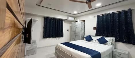 Un dormitorio con una cama, ventilador de techo y armario.