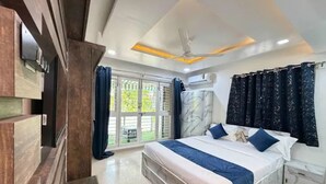 A bedroom with a bed, a ceiling fan, a window with curtains, and an air conditioning unit. - Fabhotel Balewadi Stay Inn (Pune)