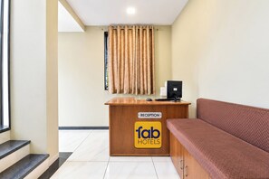 A reception area with a desk labeled 'Reception' and a sign for 'fab hotels'. - FabHotel D9 (Indore)