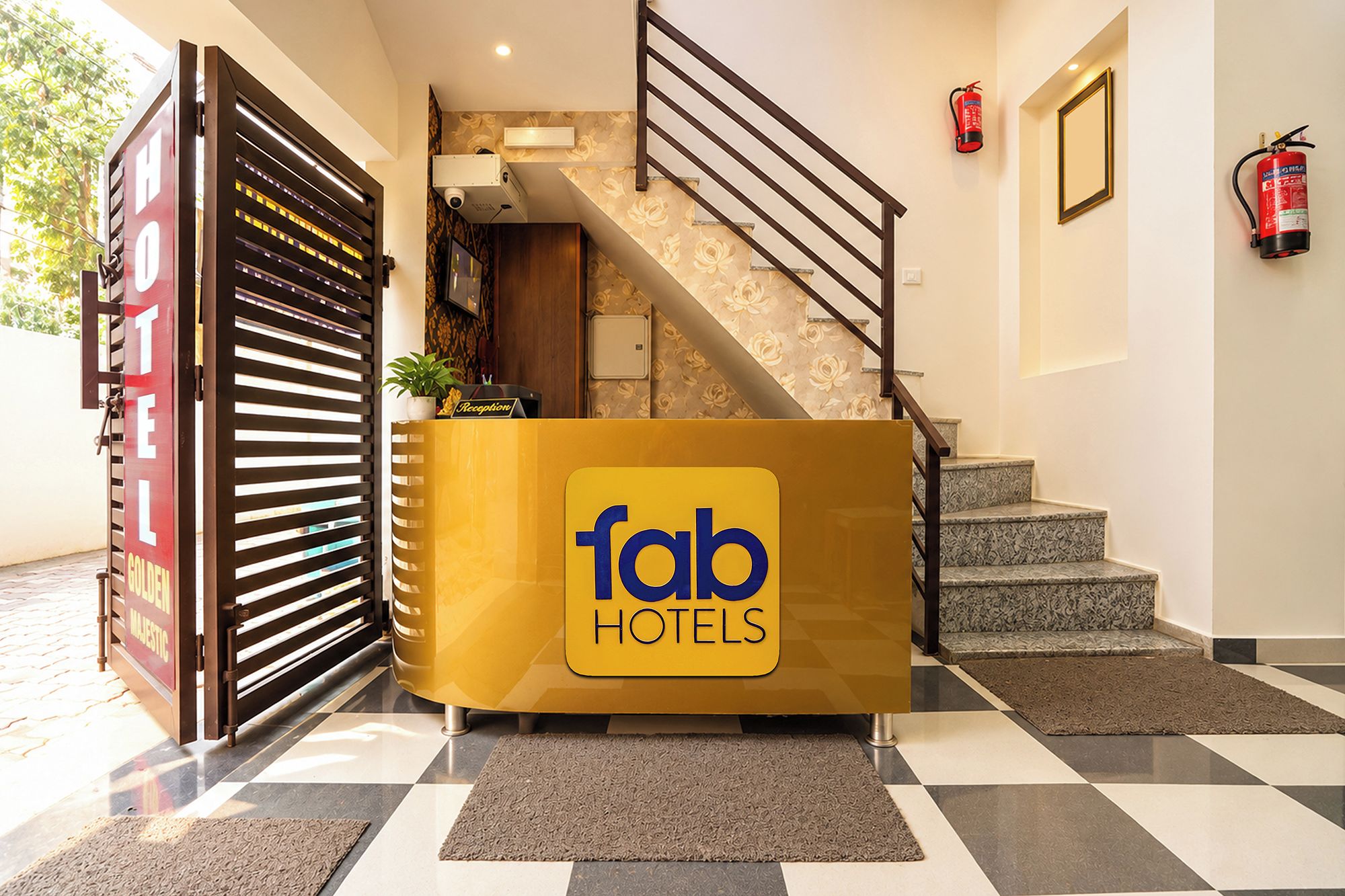 A hotel reception desk with a staircase and fire safety equipment.