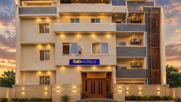 A multi-story hotel with a modern design, featuring balconies, air conditioning units, and a prominent sign for 'fabHOTELS'. - Fabhotel Golden Majestic (Prayagraj)