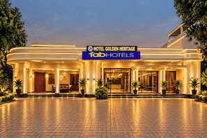 A hotel entrance with a sign for 'Hotel Golden Heritage' and 'Tab Hotels'.