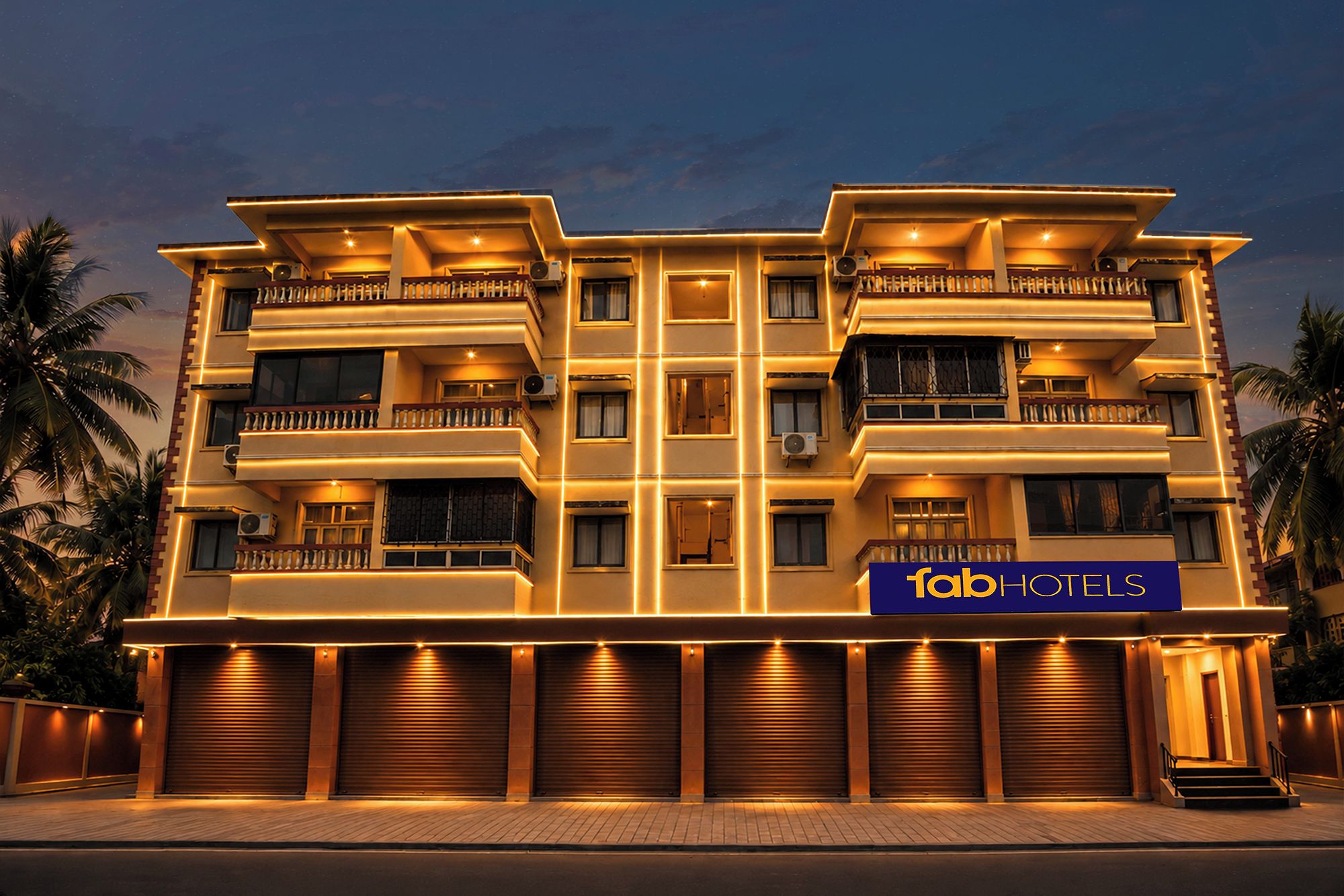Un hotel de varios pisos con balcones, unidades de aire acondicionado y un cartel que dice 'fabHOTELS'.