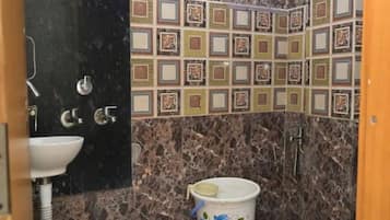 Un baño con lavamanos, inodoro, ducha y azulejos decorativos.