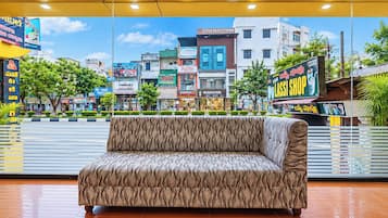 A patterned sofa in a lobby with a view of a cityscape through large windows.