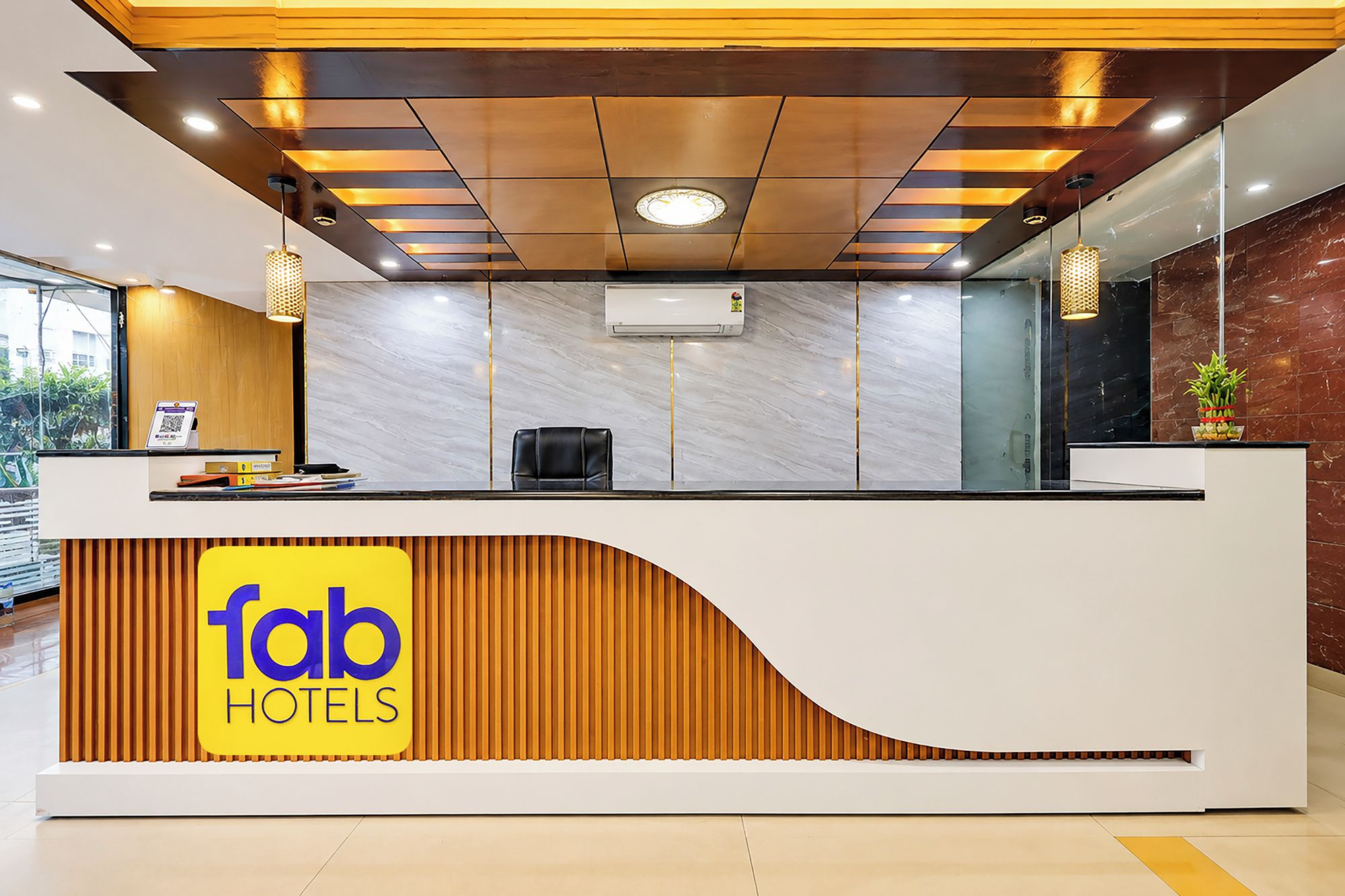 Una recepción de hotel con diseño moderno, un logotipo y un área de descanso.