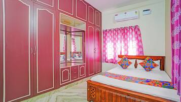 Quarto com cama, guarda-roupa, espelho e ar condicionado.