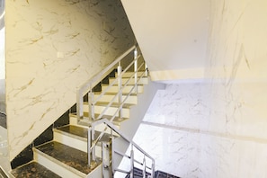 A staircase with marble walls and metal railings. - FabHotel Metro Star (New Delhi)