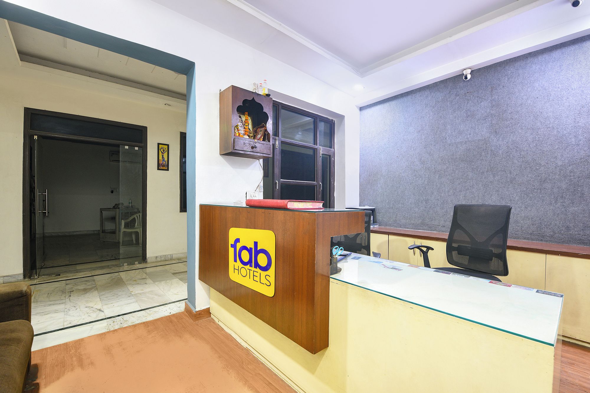 A hotel reception desk with a glass top, a wooden counter, and a sign that reads "fab hotels".