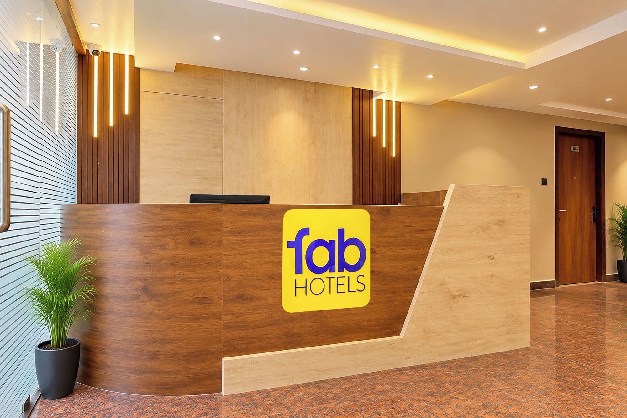 Una recepción con detalles de madera y el logotipo de 'fab hotels'.