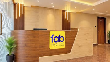 Una recepción con detalles de madera y el logotipo de 'fab hotels'.