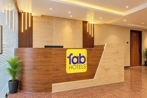 Una recepción con detalles de madera y el logotipo de 'fab hotels'.