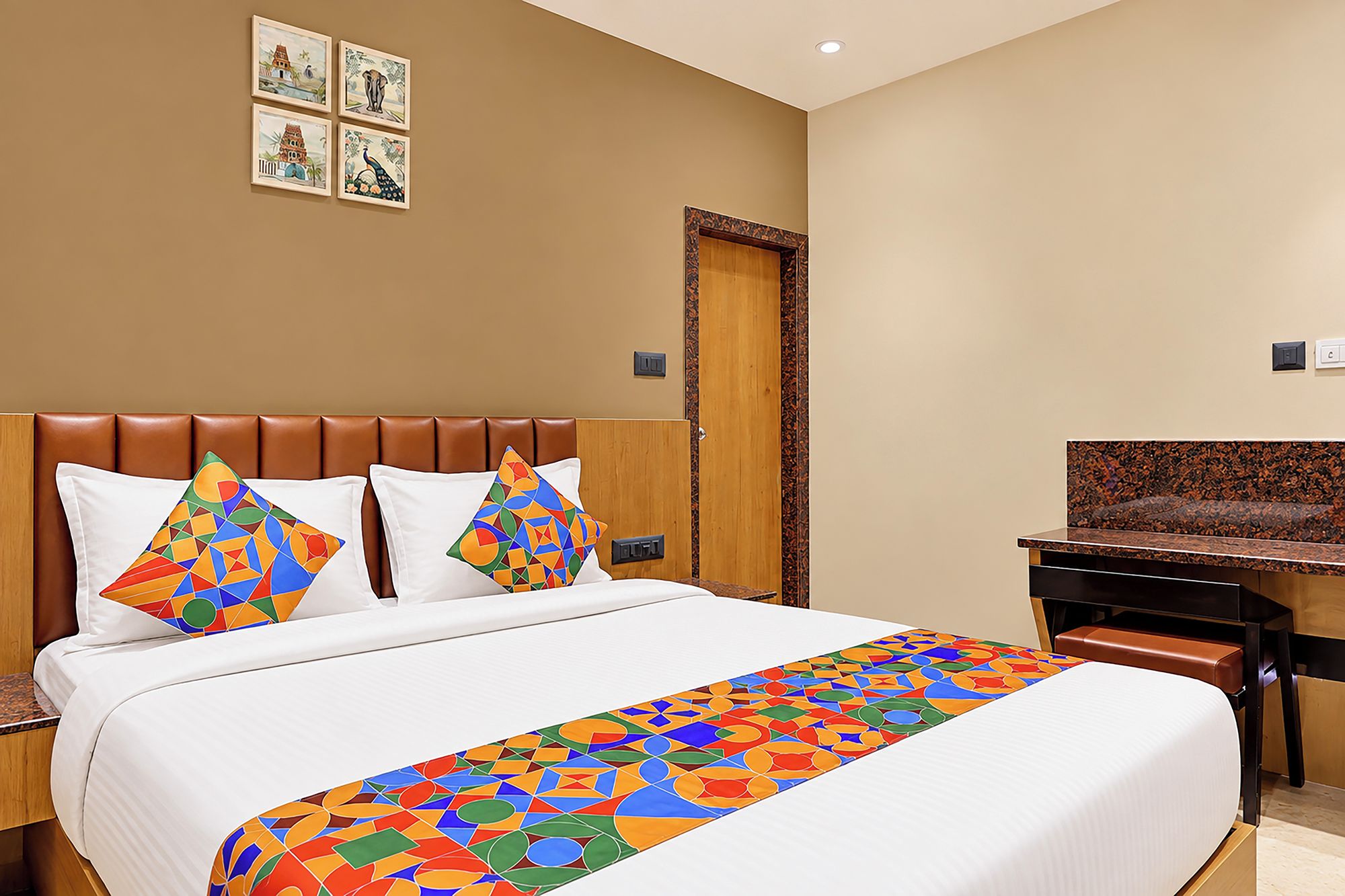 Una habitación de hotel con una cama, un escritorio y una puerta.