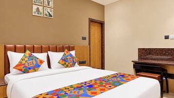 Una habitación de hotel con una cama, un escritorio y una puerta.