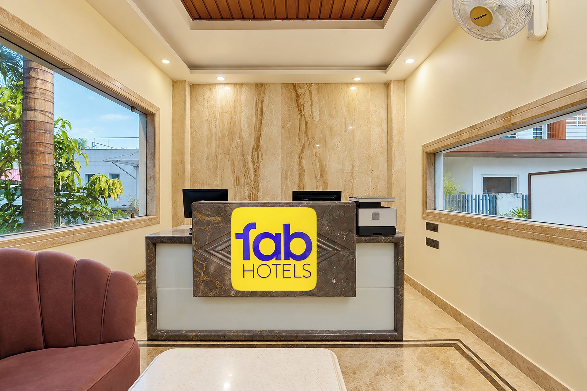 Un comptoir d’accueil avec une enseigne « Tab Hotels », un plafond en bois et une vue sur l’extérieur.