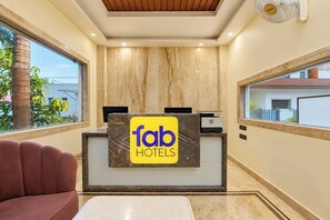 Een receptiebalie met een 'Tab Hotels' bord, een houten plafond en uitzicht op buiten.