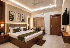 A modern bedroom with a large bed, bedside tables, a ceiling fan, and a TV mounted on the wall.