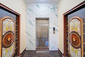 Un ascensor con paredes de mármol y puertas decoradas.