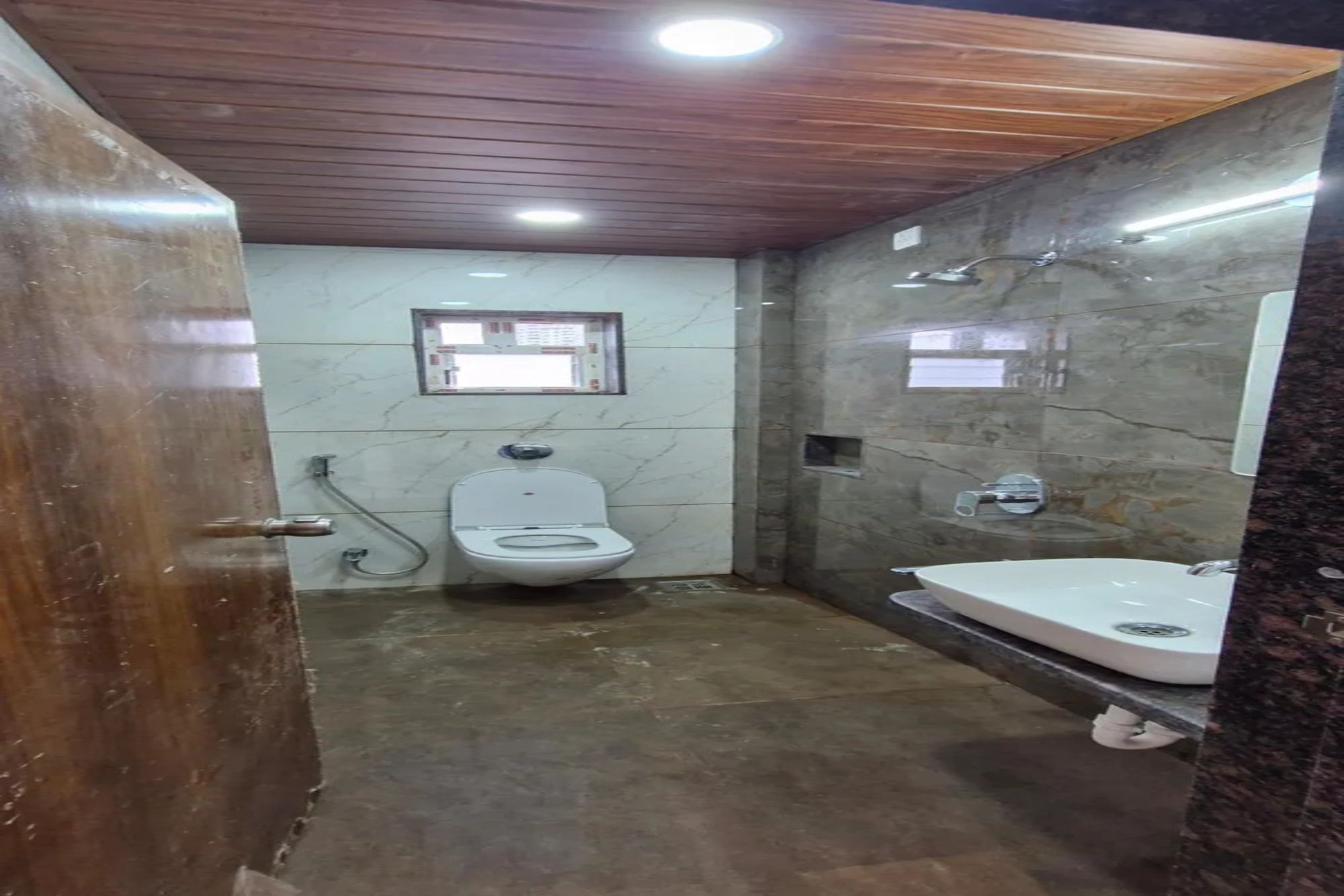 Casa de banho com sanita, chuveiro e lavatório.