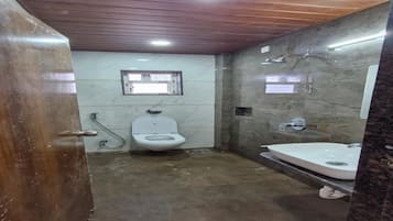 Casa de banho com sanita, chuveiro e lavatório.