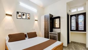 Un dormitorio con cama, lámparas de noche, armario, espejo y ventana.