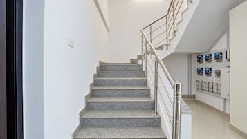 Una escalera con barandilla de metal que conduce a una plataforma con cuadros eléctricos.