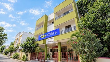 Un hôtel reconnaissable à son enseigne bien visible, doté de plusieurs étages et d’une entrée sécurisée par un portail.