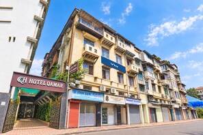 A multi-story building with a sign for Hotel Qamar and various shops on the ground floor.