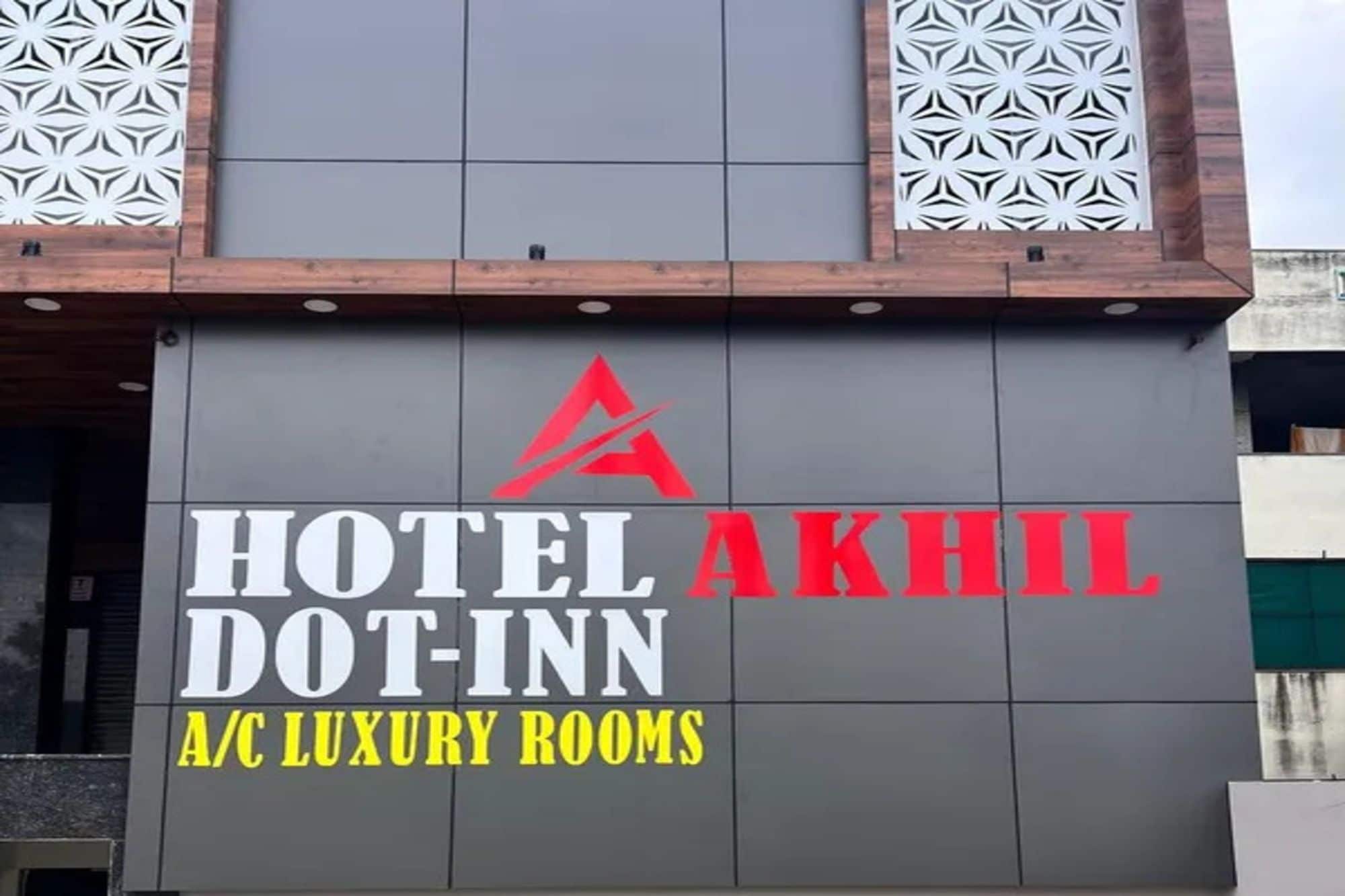 Ein Gebäude mit einem Schild, auf dem 'HOTEL DOT-INN A/C LUXURY ROOMS' steht.