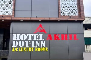 Un edificio con un cartel que dice 'HOTEL DOT-INN A/C LUXURY ROOMS'.