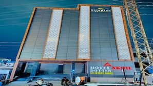 Un hotel de diseño moderno, con un logo y señalización destacados para 'HOTEL AKHIL A/C LUXURY ROOMS'.