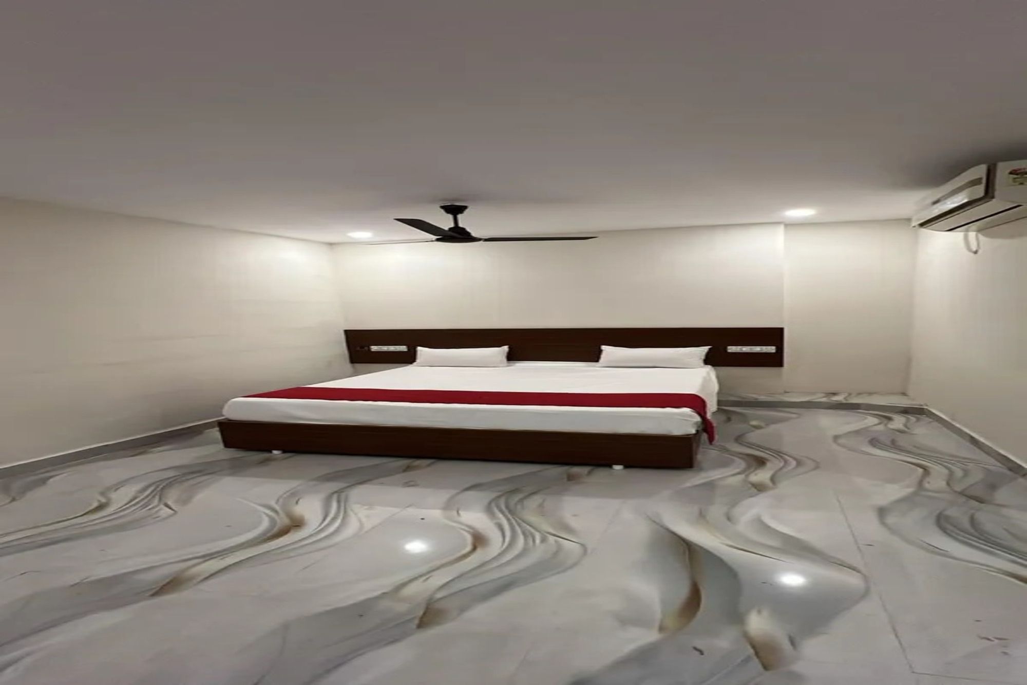 Un dormitorio con cama, ventilador de techo y suelo con diseño de mármol.
