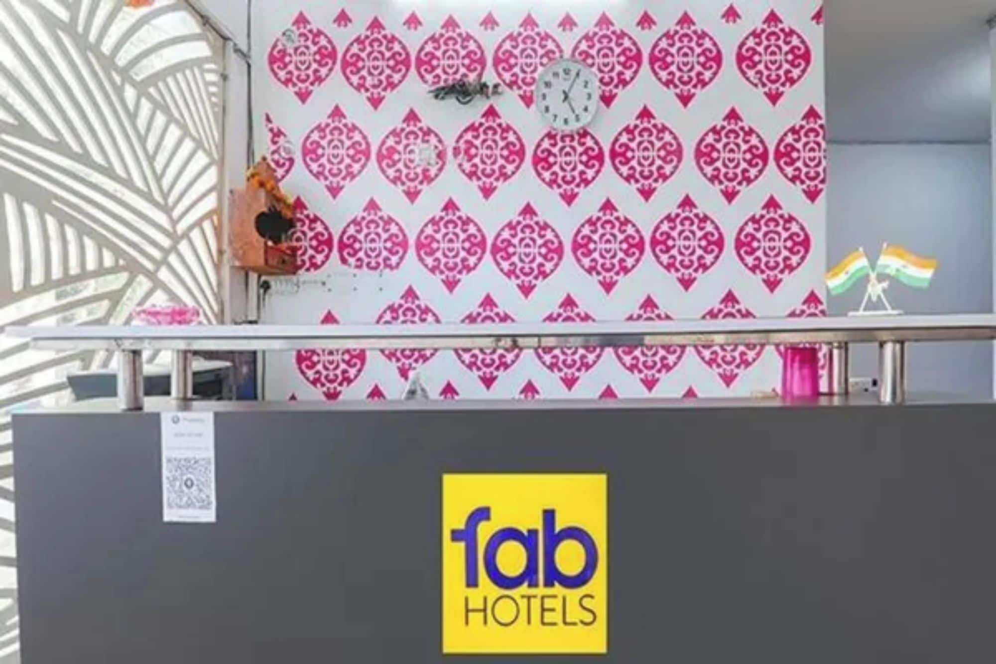 A reception desk with a patterned wall, a clock, and a flag.