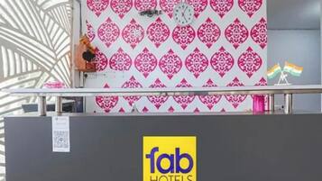 Bancada de recepção com parede estampada, um relógio e uma bandeira.
