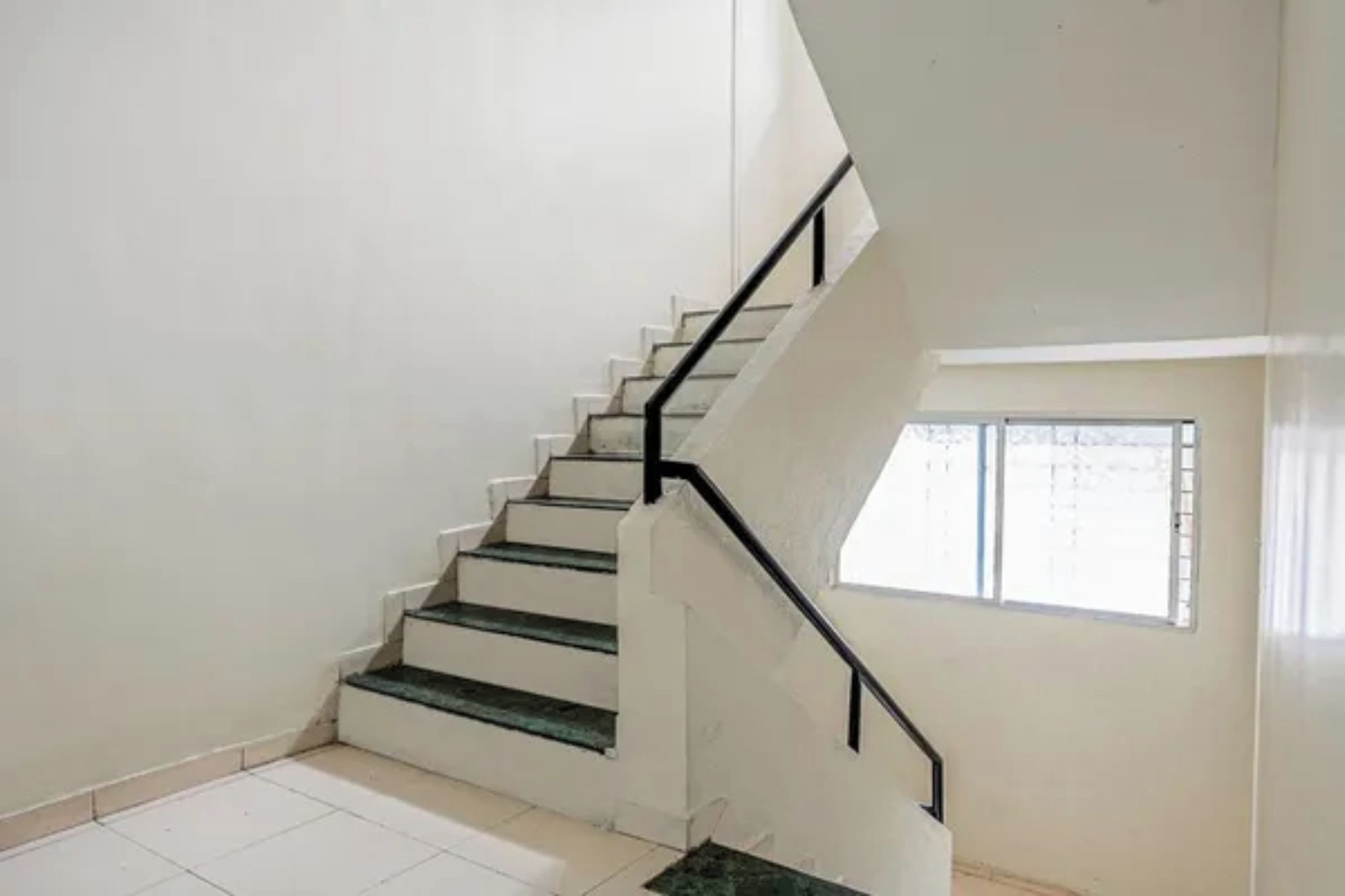 A staircase with black handrails leading to an upper floor.