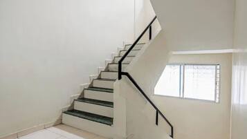 A staircase with black handrails leading to an upper floor.