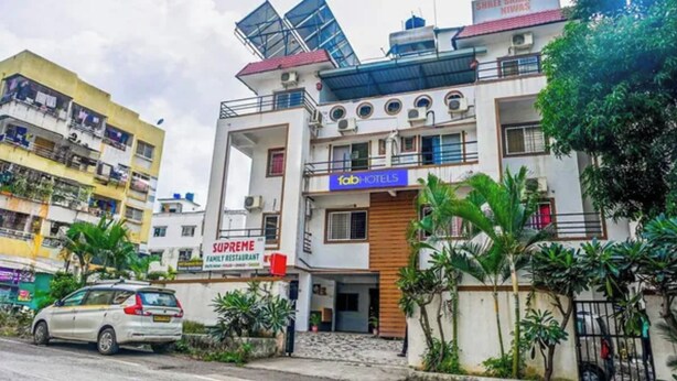 Un edificio de varios pisos con un restaurante familiar llamado 'Supreme' y un hotel llamado 'fabHOTELS'.