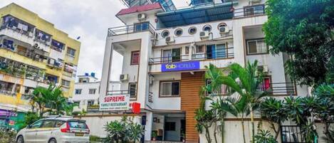 Un edificio de varios pisos con un restaurante familiar llamado 'Supreme' y un hotel llamado 'fabHOTELS'.