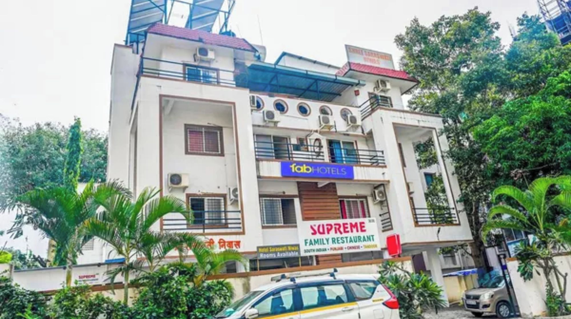 A multi-story building with a family restaurant named 'Supreme' and a hotel named 'Fab Hotels'.