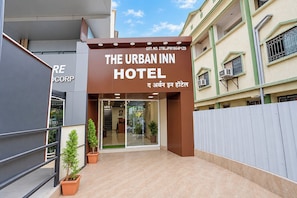 The entrance to The Urban Inn Hotel with a clear sign, a gated entrance, and potted plants. - Fabhotel The Urban Inn (Nagpur)