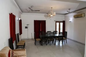 Un espace repas agrémenté d’un lustre, de ventilateurs de plafond et d’une table à manger avec des chaises.